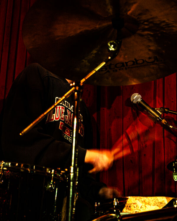 Drummer against Red Curtain